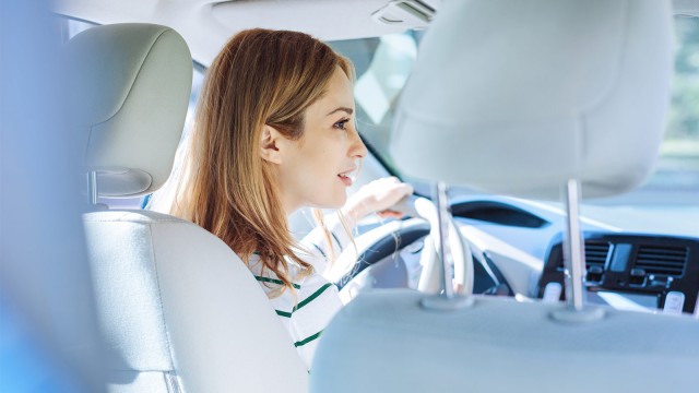 Frau sitzt im Auto hinter Lenkrad