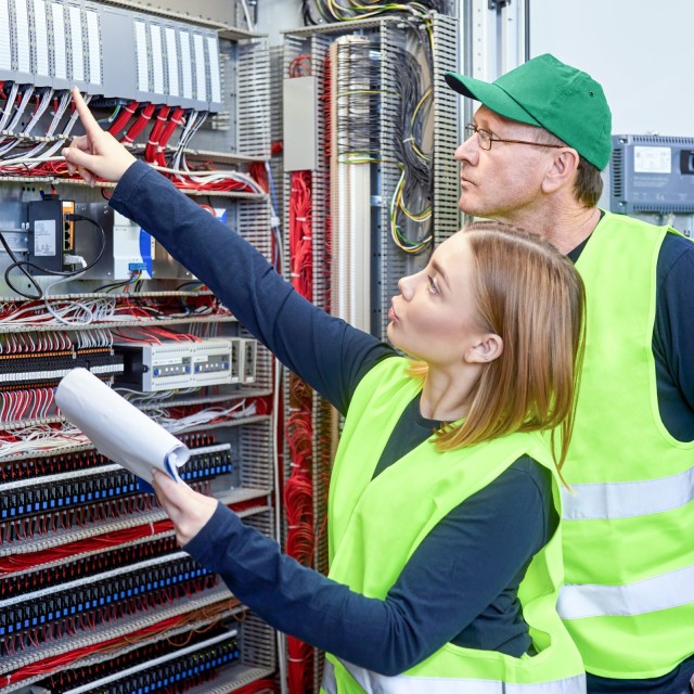 Zwei Elektriker vor einem Stromkasten