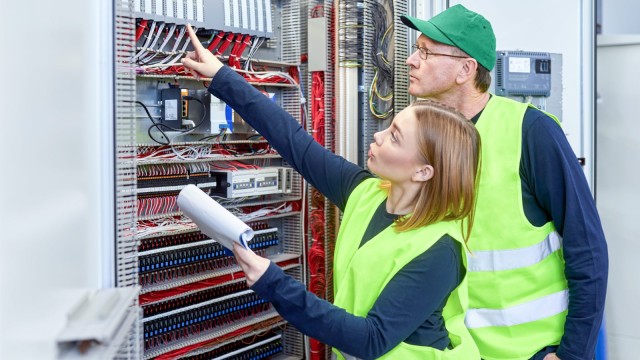 Zwei Elektriker vor einem Stromkasten