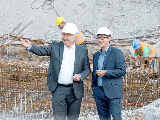 Zwei Männer mit Helm auf einer Baustelle