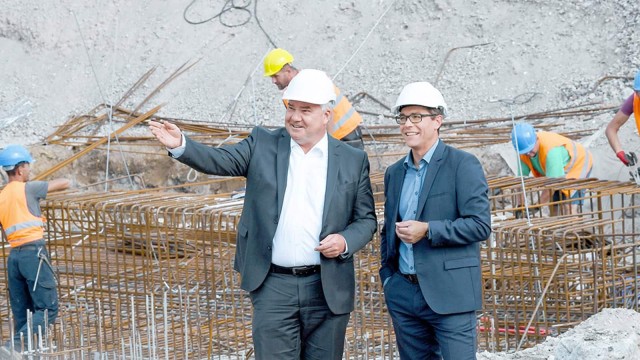 Zwei Männer mit Helm auf einer Baustelle