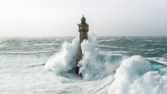 Große Welle, die auf einen Leuchtturm trifft 